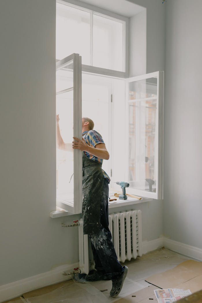 services-02 Professional installing a window in a bright modern apartment interior.